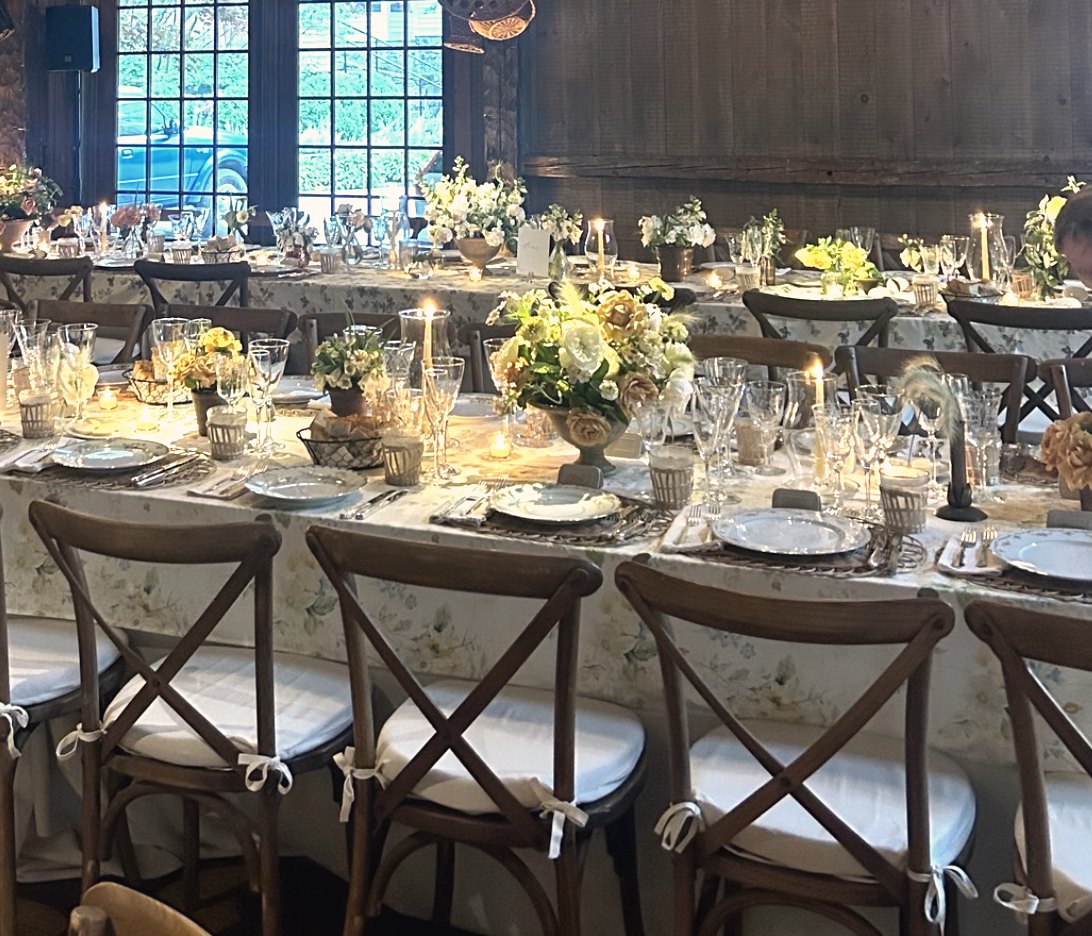 Long tables lit with candles in a timber hall at a recent event